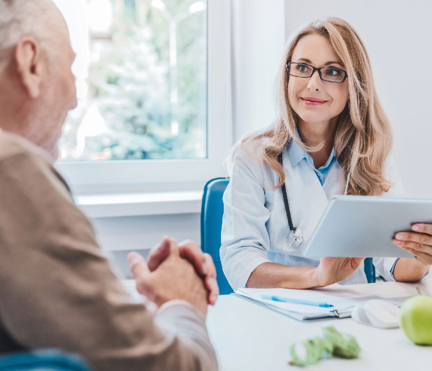 Female provider with tablet speaking to male patient