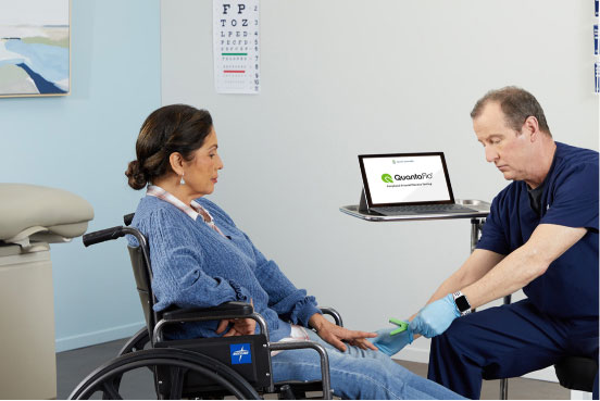 Male provider performing QuantaFlo PAD test on female patient