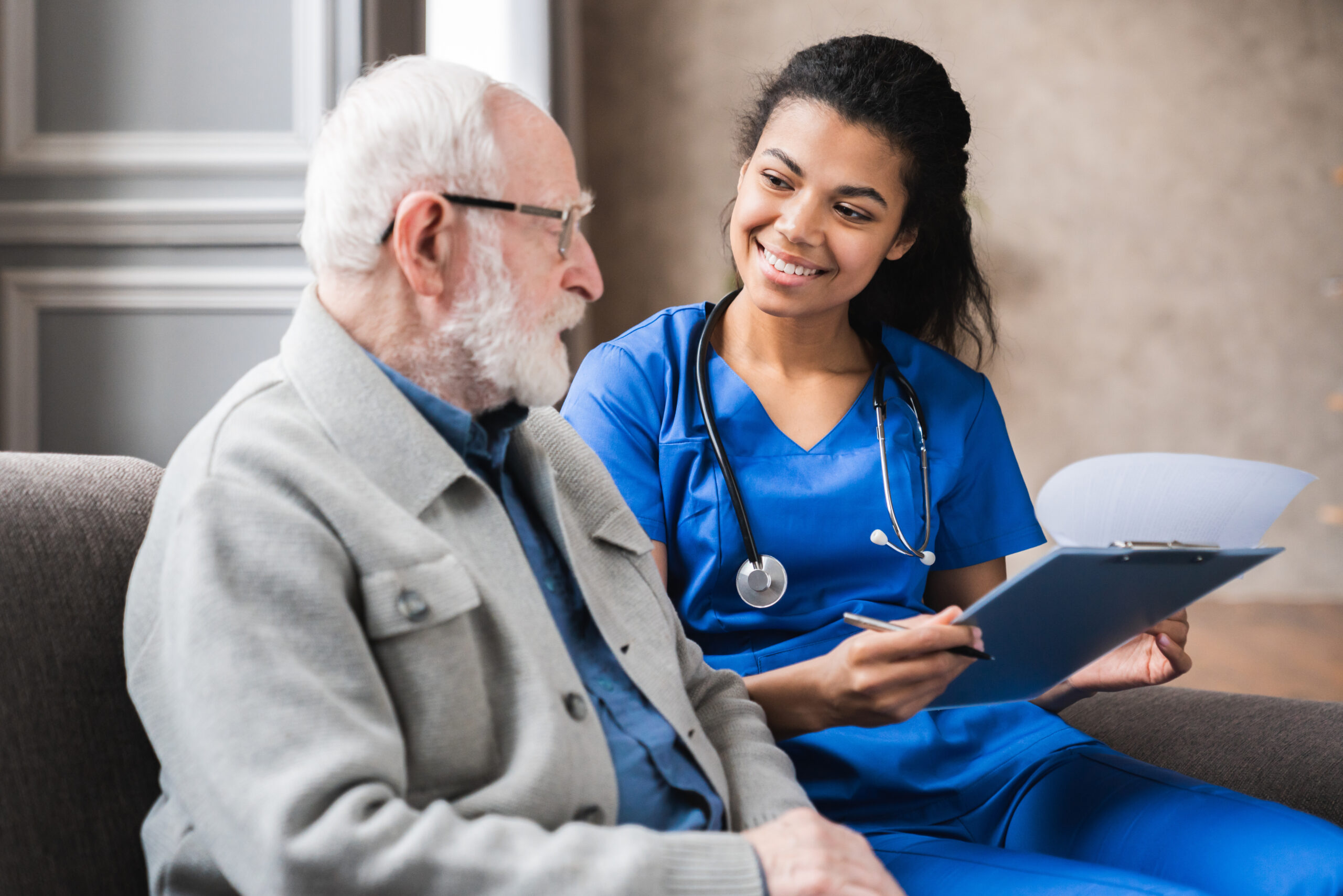 Smiling female provider sharing test results with elderly male patient